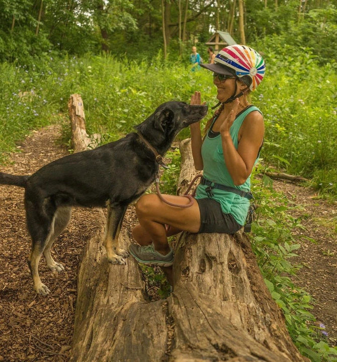 Dog practicing safe adventure training in Milwaukee with a trainer, preparing for hiking and biking outdoors.